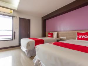 a hotel room with two beds with red pillows at OYO 1127 Baan Siam Hotel in Chiang Rai