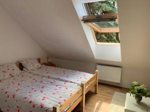 a bedroom with a bed with red flowers on it at Búzavirág Apartman in Szentbékkálla