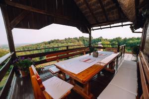 a wooden table and chairs on a balcony with a view at Kuća za odmor Stara hiža in Selnica