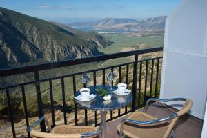a table and chairs on a balcony with a view at Acropole Delphi City Hotel in Delphi