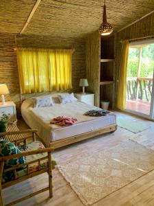 een slaapkamer met een groot bed en gele gordijnen bij Turan Hill Lounge in Faralya