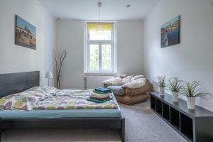 een slaapkamer met een bed en een stoel bij TopApartmany in Praag