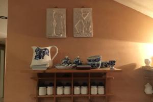 una mensola piena di ceramiche blu e bianche su un muro di Loft Dora ad Agnone