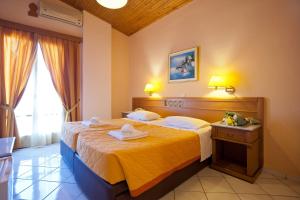 a hotel room with a large bed with yellow sheets at Acropole Delphi City Hotel in Delphi