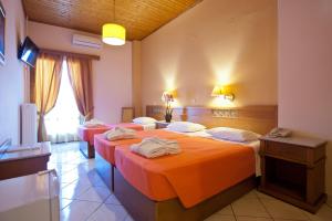 a hotel room with two beds and a television at Acropole Delphi City Hotel in Delphi