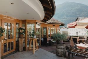 a restaurant with a patio with tables and chairs at Hotel Kreuz in Pfunds