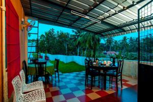 a patio with a table and chairs on a checkered floor at Vasudevam Premium Suites in Trivandrum