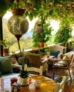 een patio met een tafel, stoelen en planten bij Turan Hill Lounge in Faralya