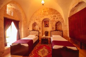 two beds in a room with arched ceilings at Maristan Tarihi Konak in Mardin