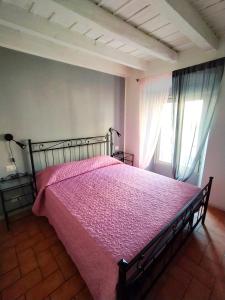 um quarto com uma cama com uma colcha rosa em Appartamento Monet em Bérgamo