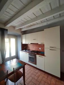 uma cozinha com armários brancos e uma mesa em Appartamento Monet em Bérgamo