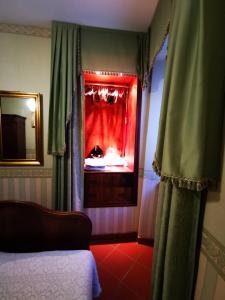Schlafzimmer mit einem Bett und einem Fenster mit Vorhängen in der Unterkunft La suite del Cardinale in Montefiascone