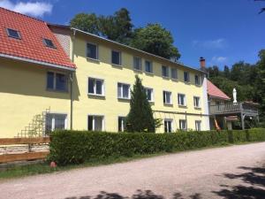 um grande edifício amarelo com um telhado vermelho em Ferienwohnung Wolf em Gräfenroda