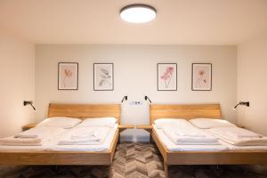 2 Einzelbetten in einem Zimmer mit Bildern an der Wand in der Unterkunft ART Hostel & Apartments in Dvůr Králové nad Labem + 72 Fotos