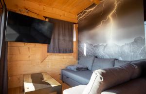 a living room with a couch and a tv at Domek Nad Doliną in Orawka