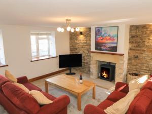a living room with two red couches and a fireplace at The Forge in Hexham
