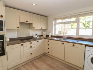a kitchen with white cabinets and a sink at The Forge in Hexham