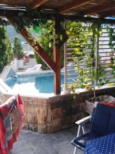 uma piscina com uma pérgola e cadeiras em Kuća na obali jezera sa bazenom em Međuvršje