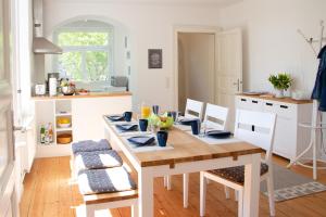 a kitchen with a wooden table and chairs in a room at Ferienwohnung Hufelandstern bis 7 Personen - mit E-Ladesäule! in Bad Wildungen