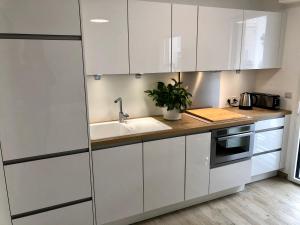 a kitchen with white cabinets and a sink at Brand new studio in the heart of Cannes in Cannes