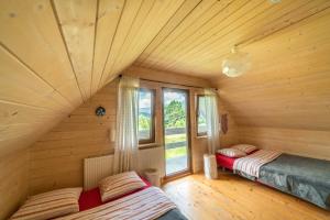 a room with two beds in a log cabin at U Szoguna in Wetlina