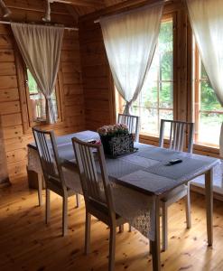 comedor con mesa y sillas en una cabaña en Honeyhill Villa Karhu, en Isnäs