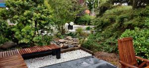 a garden with a wooden bench and a pond at Huize Triangel - Wellness studio met sauna in Noordwolde