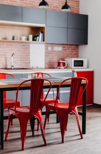 uma cozinha com uma mesa de madeira e cadeiras vermelhas em Little Home em Liptovský Mikuláš