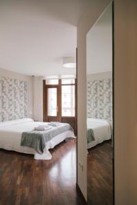 a bedroom with two beds and a mirror at Casa peñasBLANCAS en Duruelo de la sierra Soria 12personas in Duruelo de la Sierra