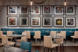 a restaurant with tables and chairs and pictures on the wall at Hermitage Hotel Prague in Prague