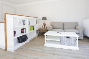 a living room with a couch and a table at Hotel & Ferienunterkünfte Hus Seeblick in Fehmarn