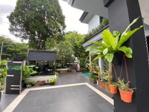 新山的住宿－OneRiimba Private Pool & Garden Residence Johor Bahru，建筑一侧种植盆栽植物的花园商店