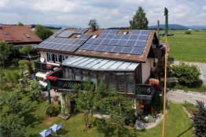 ein Haus mit Sonnenkollektoren auf dem Dach in der Unterkunft Ferienwohnungen Claus in Frauenau