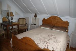 a bedroom with a wooden bed and a table and chairs at Gite chez Gilles Lévesque in Saints-Anges