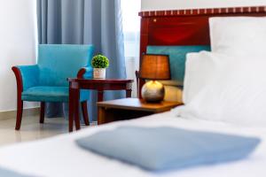 康斯坦察Lira Pacific Aparthotel的一间卧室,里面有一张床、一把椅子和一张桌子