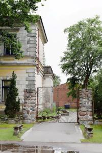 uma casa com um portão em frente a um edifício em Stone Garden em Liepāja