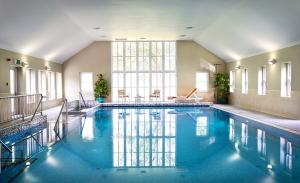 a large swimming pool with blue water in a building at Dromoland Castle in Newmarket on Fergus