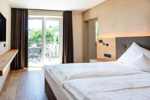 ein Hotelzimmer mit einem Bett und einem Balkon in der Unterkunft Hotel Hofer in Dorf Tirol