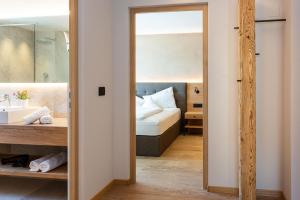 baño con lavabo y 1 cama en una habitación en Hotel Hofer, en Tirolo