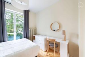 1 dormitorio con cama, escritorio y espejo en Schönes Haus mit Garten nähe Lesum, en Bremen