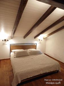 a bedroom with a large bed with white sheets and pillows at Haus am Osterbrünnl in Ruhmannsfelden