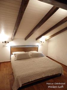 ein Schlafzimmer mit einem großen Bett mit weißer Bettwäsche und Kissen in der Unterkunft Haus am Osterbrünnl in Ruhmannsfelden