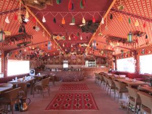 a dining room with tables and chairs and christmas decorations at Wadi Rum Caravan Camp in Wadi Rum