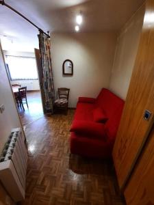 a living room with a red couch and a table at Altissim Grizzly in Pas de la Casa