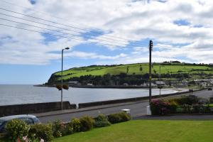 a view of a body of water with a hill at Channel Vista in Glenarm