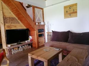 uma sala de estar com um sofá e uma mesa em Vikendica Ranč Terzić em Čačak