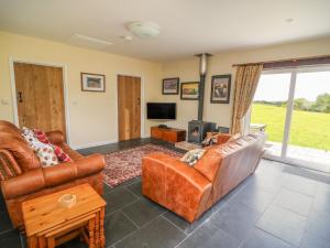 a living room with leather furniture and a tv at Blaenffynnon Bach in Carmarthen