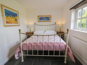 a bedroom with a bed with a red and white bedspread at Blaenffynnon Bach in Carmarthen