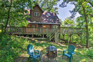 Wauzeka的住宿－Secluded A-Frame Hideaway with Wraparound Deck!，树林中的小屋,配有两把椅子和一张桌子
