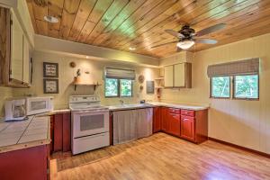 cocina con armarios rojos y ventilador de techo en Secluded A-Frame Hideaway with Wraparound Deck! en Wauzeka